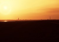 Westturm und Leuchtturm im Gegenlicht
