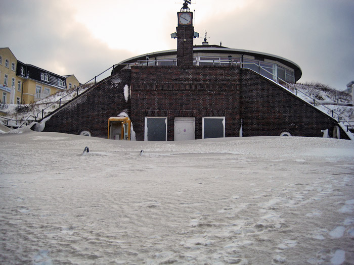 Schneebedeckte Sandberge vor der Uhrtreppe